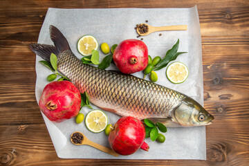 top view fresh fish with pomegranates on a wooden table food seafood dish ocean