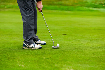 Fototapeta na wymiar With a putt, hit the hole with the golf ball
