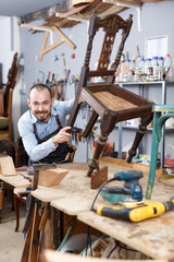 Craftsman engaged in retro chair repair in modern workshop