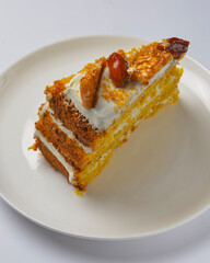 Closeup of one piece pumpkin layer cake with caramel and nut topping. Seasonal autumn cake with caramel syrup.