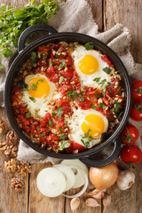 Ajarian Chirbuli is a dish from Georgia Ajara region made with eggs, tomatoes, onion and walnuts, it is a popular breakfast meal closeup in the pan. Vertical top view from above