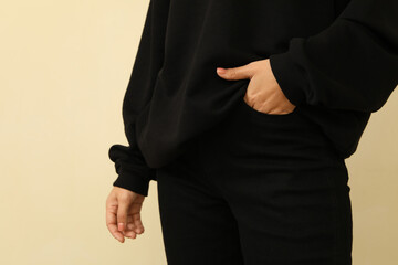 Woman in black sweatshirt holding hand in pocket of black jeans