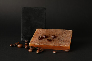Natural soap and coffee seeds on black background