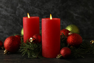 Candles, baubles and pine branches on wooden background