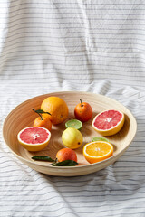food, healthy eating and vegetarian concept - close up of citrus fruits on wooden plate