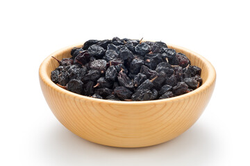 Black currant raisins in a wooden bowl. Isolated on white background.