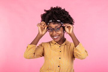 African american businesswoman holding glasses and smiling. Portrait of young woman looking at camera. Beautiful woman wearing yellow shirt.