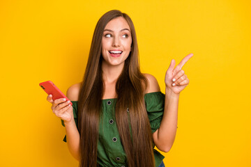 Portrait of attractive cheerful long-haired girl using device demonstrating copy space ad isolated...