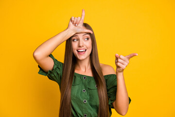 Portrait of attractive cheerful brown-haired girl bullying you fool isolated over bright yellow color background