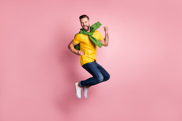 Fototapeta na wymiar Full size photo of cheerful bearded brown haired man jump air raise fists winner isolated on pastel pink color background