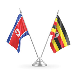 Uganda and North Korea table flags isolated on white 3D rendering