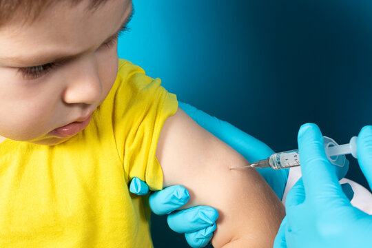 The doctor or nurse injects the child in the arm' in the shoulder. The concept of vaccination in health and medicine, vaccines for children. BCG tuberculosis, DPT.