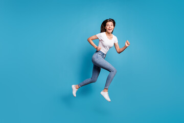 Fototapeta na wymiar Full body profile side photo of nice funky woman amazed sale run jump empty space wear jeans isolated on blue color background