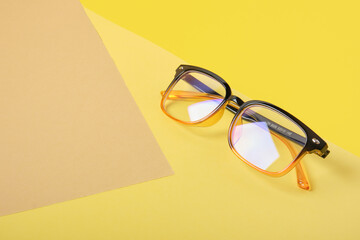 glasses on beige and yellow background, geometric background, trend colors, illumination yellow