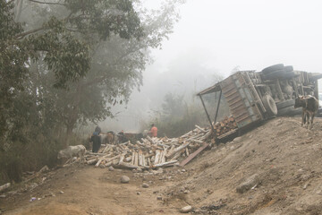 Obraz premium scene during foggy weather where wooden logs fallen from a accidented truck