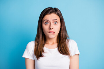 Photo of sad guilty young lady wear white clothes biting lip isolated blue color background