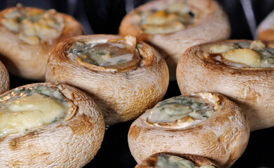 Fototapeta na wymiar Baked mushrooms stuffed with cheese. Cooking food in the oven at home.