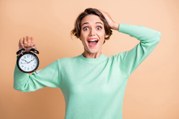 Photo of young attractive girl amazed shocked surprised crazy hold clock hand touch head isolated...