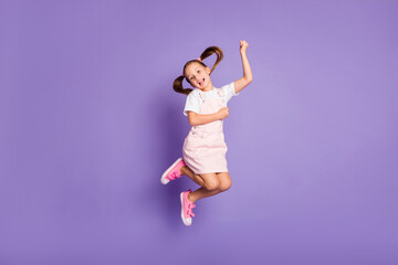Full size photo of charming happy little girl jump up air weekend positive isolated on purple color...