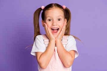 Photo of shocked amazed girl wear pink dress hold hands cheekbones surprise isolated on purple...