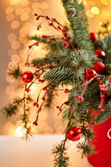 Christmas arrangement with Norwegian pine Nobilis and decorated with Christmas decor in a metal Cup. Garland bokeh on background. Christmas love. Dark wooden table sprinkled with snow