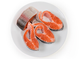 Top view of uncooked rainbow trout steaks on white dish