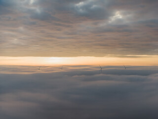 Amanecer con mar de nubes de niebla y molinos eólicos