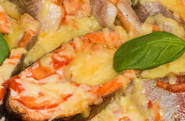 Rainbow trout steaks baked with cheese, top view, background