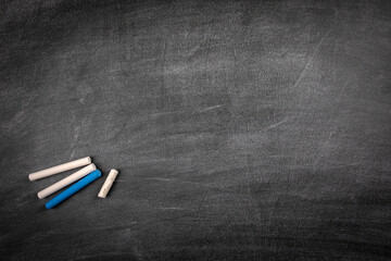 Black chalk board with chalk pieces. Scratches and white lines. Space for text and drawings