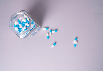 white and blue pills on a gray background. medical background