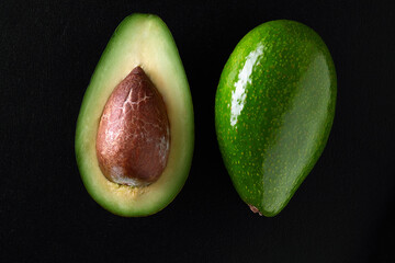 Macro shot of fresh avocados cut in a half on the black background