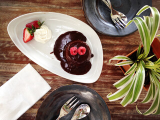Top view of dessert, the chocolate lava cake, topped with raspberries and strawberries.