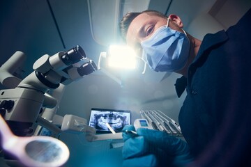 Dentist examining patient with dental equipments