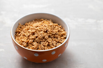 flakes wheat in the bowl on ceramic background