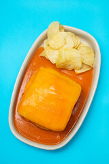 typical Portuguese food Francesinha in dish on ceramic background