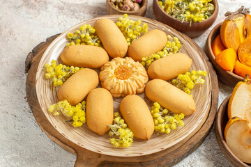 close-up photo of a plate of sweet cookies on wooden platter and different ingredients around it