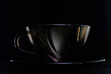 tinted coffee cup on black background with backlight