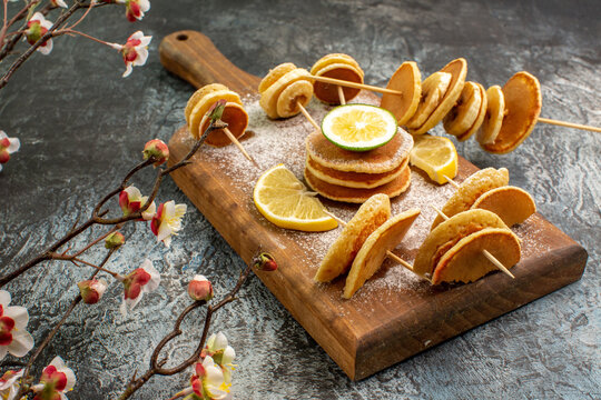 Classic American pancakes with lemons on wooden cutting board on gray background stock image