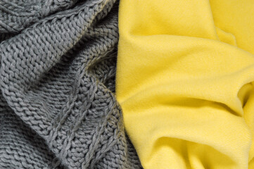 Fototapeta premium Knitted sweater or scarf as wool texture in trendy colors of year 2021 illuminating yellow and ultimate gray. Vivid textile background with fashionable winter clothes or accessories and copy space
