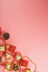 Christmas composition of decorations and Christmas toys on a pink background.