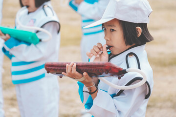 Kids playing music in marching band, cute Asian child blowing instrument on sport day in school