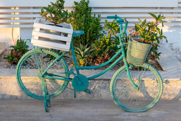 Fototapeta na wymiar Old blue decorative bike with flowers - street or garden decoaration ideas