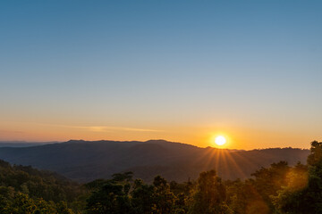 Naklejka na ściany i meble Sunset on the mountain Doi Khun Tan, Lampang, Northern, Thailand.