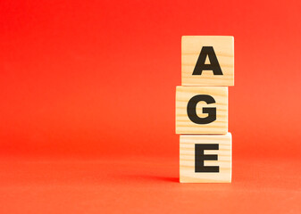 Wooden cubes with word AGE. Wooden cubes on a red background. Free space on the left.