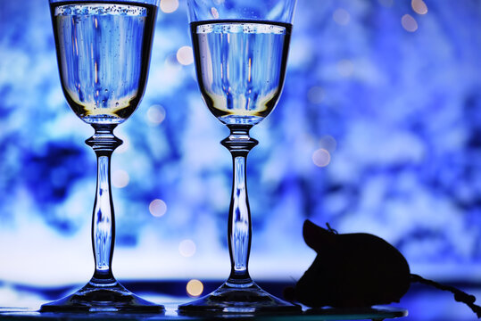 Farewell to 2020. Silhouette symbol of the year of the rat two glasses with sparkling wine.