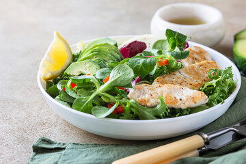 Grilled chicken breast, avocado, apple and bell pepper salad with salad leaves mix and olive oil and lemon dressing.