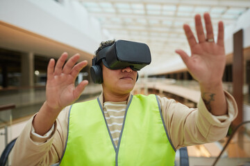 Portrait of female engineer wearing VR headset while visualizing architectural design project