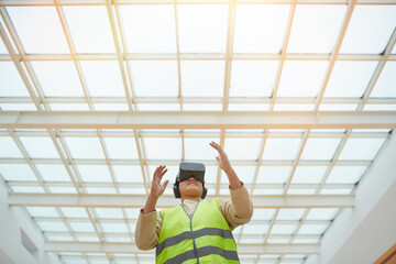Graphic low angle portrait of female engineer wearing VR headset while visualizing architectural...