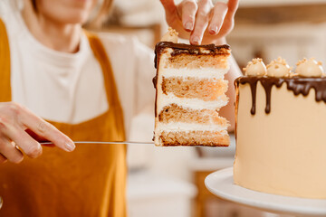 Caucasian pastry chef woman showing piece of cake with chocolate cream