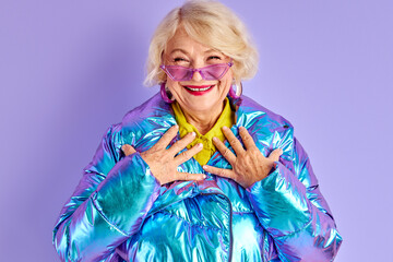 optimistic senior woman is joyful isolated in studio, mature glamorous female in winter warm fancy...